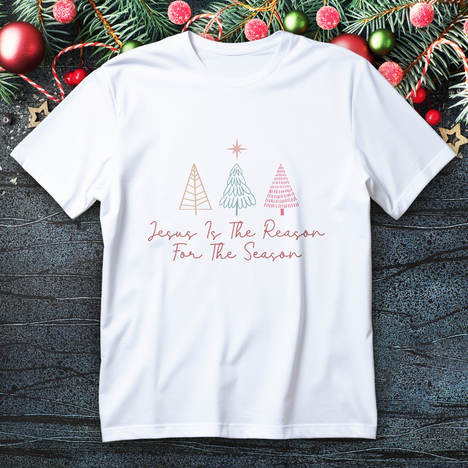 Hand-lettered “Jesus Is the Reason for the Season” with Bethlehem star and tree accents on a faith T-shirt