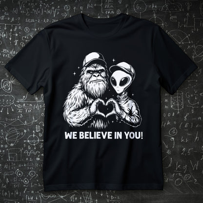 we believe in you t-shirt - bigfoot and alien making heart hands wholesome cryptid graphic
