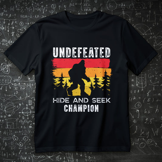 bigfoot hide and seek champion t-shirt - retro sunset forest silhouette funny cryptid tee