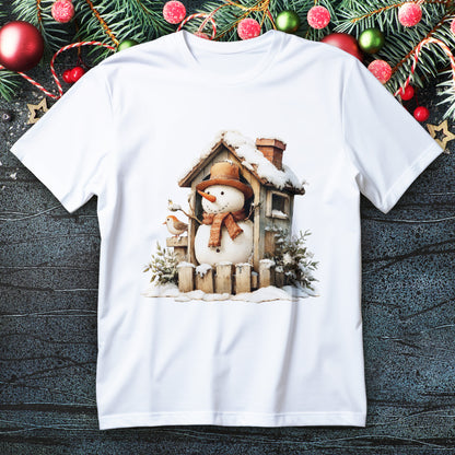 Snowman leaning on tiny cabin porch with bird, knit scarf and snowy roof on a Christmas T-shirt